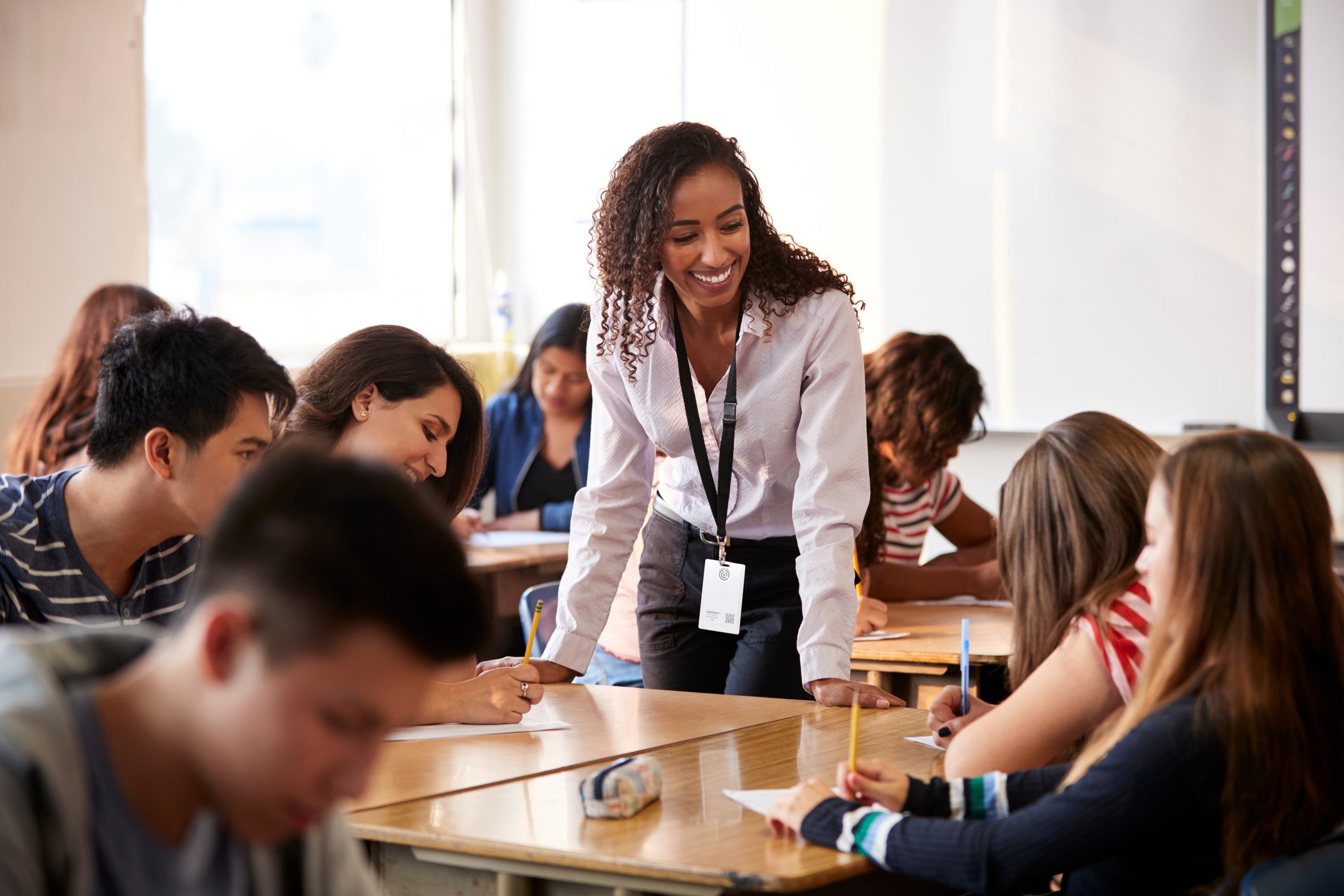 Teacher helping students at their desk