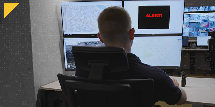 Security officer viewing multiple monitors is notified of a problem with an InformaCast alert