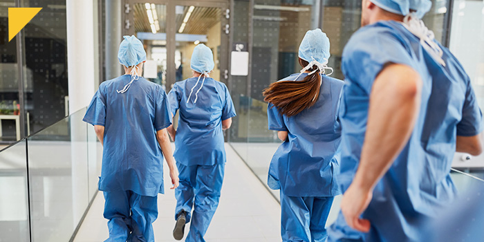 Doctors and nurses run through hallway