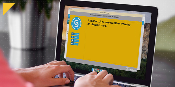 Person working on laptop with InformaCast severe weather desktop notification