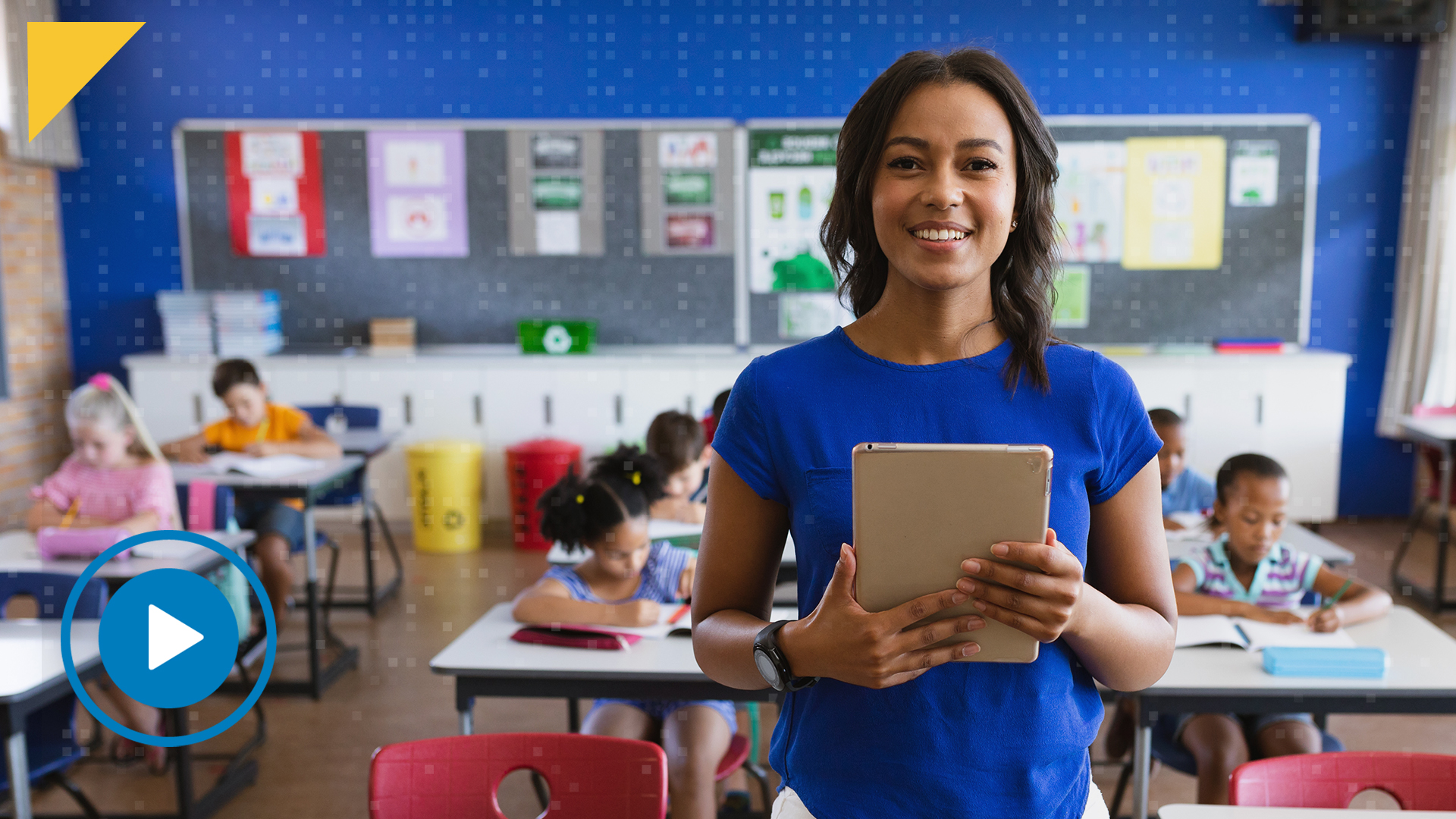 teacher holding an ipad in a classroom with students