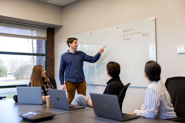 Singlewire employees work using conference room whiteboard